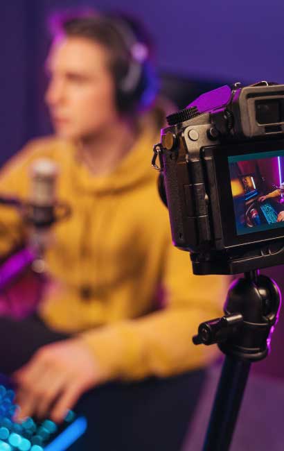 Professional Camera Filming Esports Player Streaming Online Video Game – VYB STUDIOS Camera recording a cyber sportsman streaming an online video game in a professional esports setup.